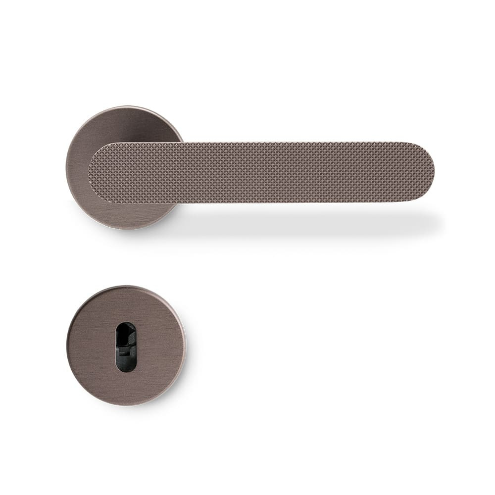 Poignée de porte Vibe Grip avec un design moderne et épuré en bronze foncé. Vibe Grip est allongé et arrondi avec une surface moletée.